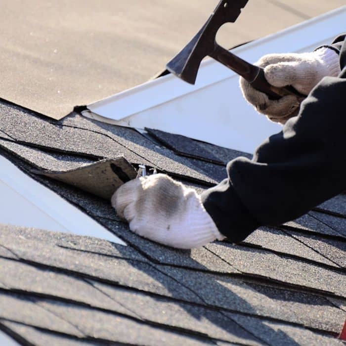 Someone installing a roof shingle